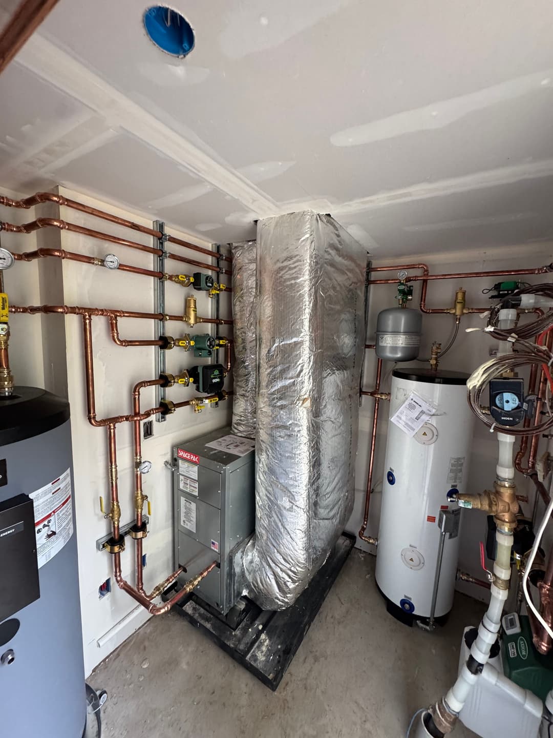 HVAC installation with insulated ducts, water heater, and copper piping in a utility room.